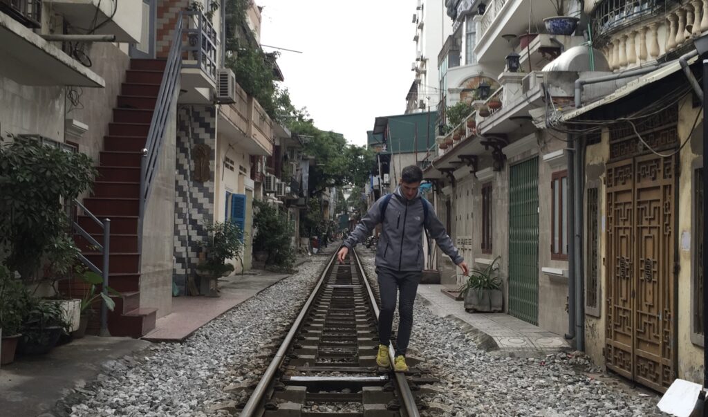 Vía del tren que pasa entre una de las estrechas calles de Hanoi