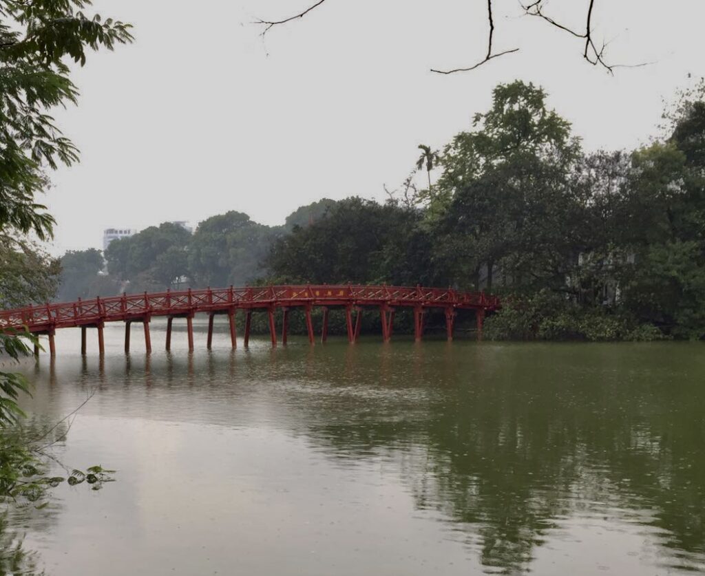 El puente rojo llamado "Cau The Huc" fotografiado desde una de la orillas del lago