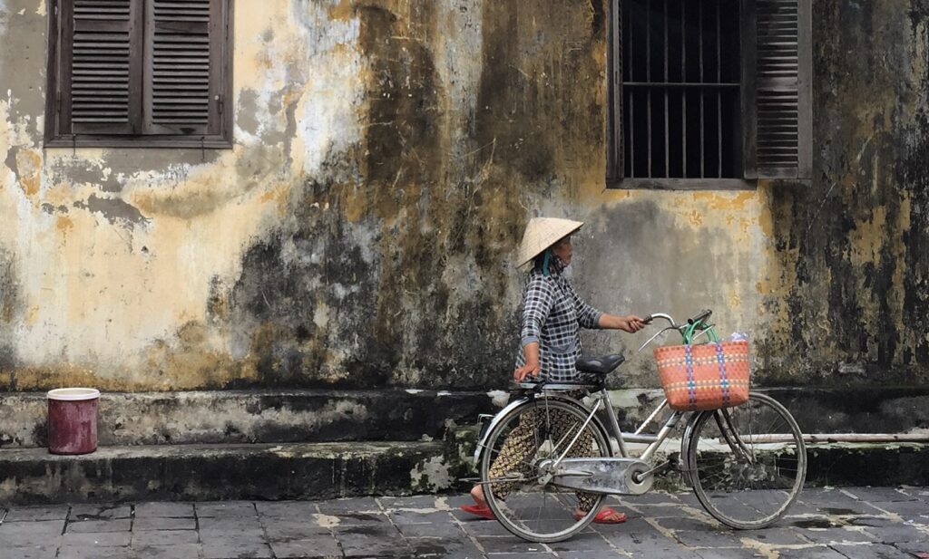 Vietnamita yendo a comprar con su bicicleta en una de las calles del Barrio Antiguo de Hanoi