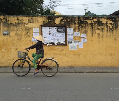 Vietnamita con gorro paseando en bicicleta