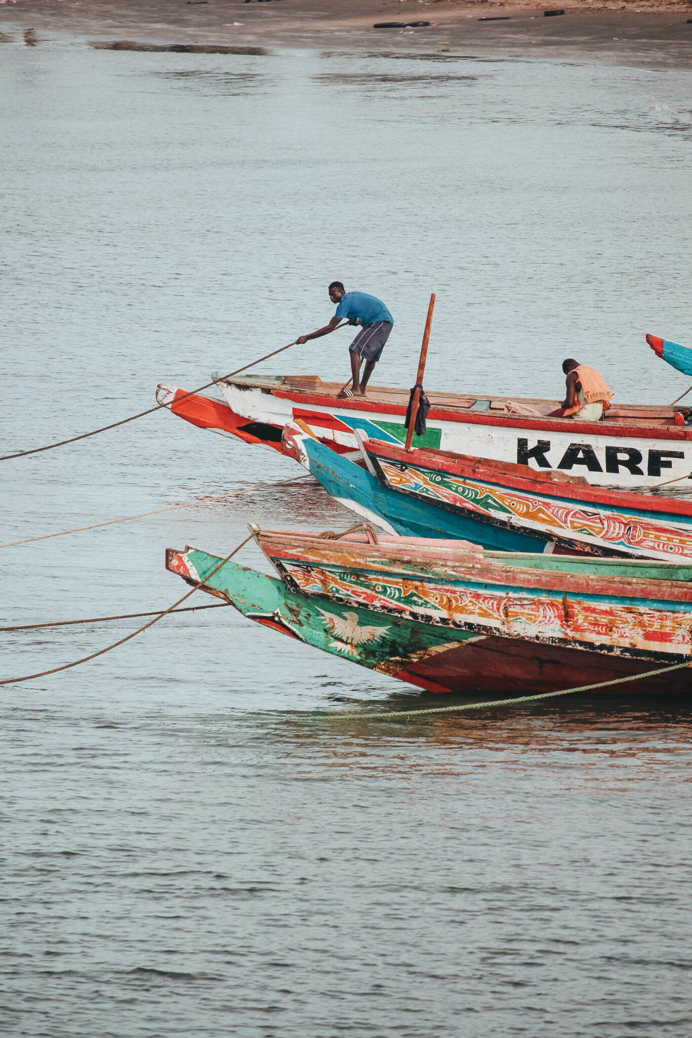 El río Gambia es un río de África de 1130 kilómetros de longitud, uno de los mayores del continente. En sus costas se puede ver un lugareño amarrando su barca.