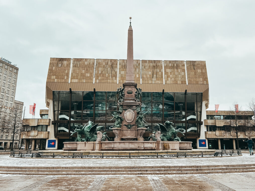 La Augustusplatz está situada al este del centro de Leipzig y es la plaza más grande de la ciudad y una de las más grandes de Europa. En ella se encuentra la Ópera de Leipzig, reconstruida e inaugurada en 1960 después de ser destruida en 1944. Tiene la peculiaridad de no contar con orquesta propia, pero eso no le impide que se celebren en ella óperas y ballets. Esta plaza está considerada como tercera más antigua de Europa. La universidad de Karl Marx es la segunda más antigua de Alemania. Fue fundada el 2 de diciembre de 1409 y desde entonces ha estado en funcionamiento, incluso durante la Segunda Guerra Mundial. Aquí estudiaron prestigiosos premios nóbeles y cientificos (Paul Ehrlich, Goethe, Heisenberg, Leibniz, Lessing, Nietzsche, Wagner...) e incluso la antigua canciller alemana, Angela Merkel, así como la ex presidenta de la República de Chile, Michelle Bachelet.