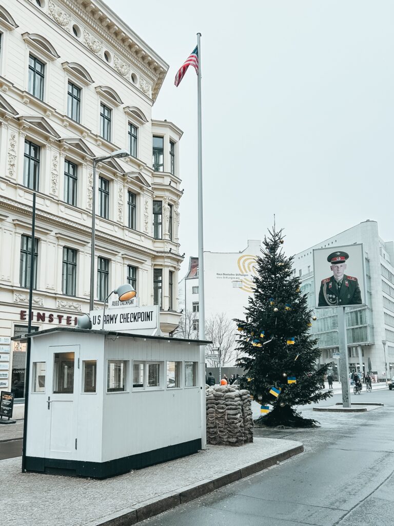 Punto de referencia histórico en Berlín, fue el más famoso de los pasos fronterizos del Muro de Berlín entre 1945 y 1990. El Checkpoint Charlie fue escenario de huidas espectaculares de Berlín Este, algunas especialmente trágicas como la muerte de Peter Fechter, desangrado en 1962 ante los ojos de los que habitaban Berlín Oeste. El 13 agosto de 2000 se inauguró esta reconstrucción de la primera caseta, tal y como era salvo por los sacos de arena, que ahora son de cemento.