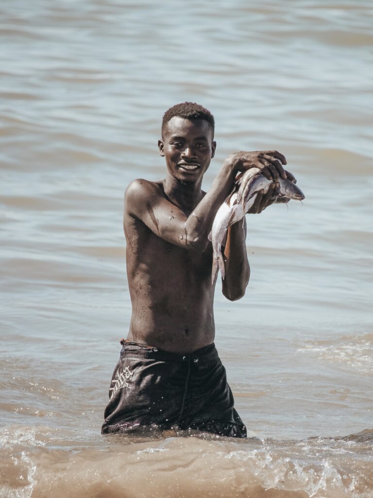 Mientras algunos barcos que acaban de regresar y llenos de mercancía negocian con los locales que se lanzan con inmensas cajas que se colocan encima de sus cabezas para poder transportar el pescado hasta la orilla, donde comienza la subasta.
