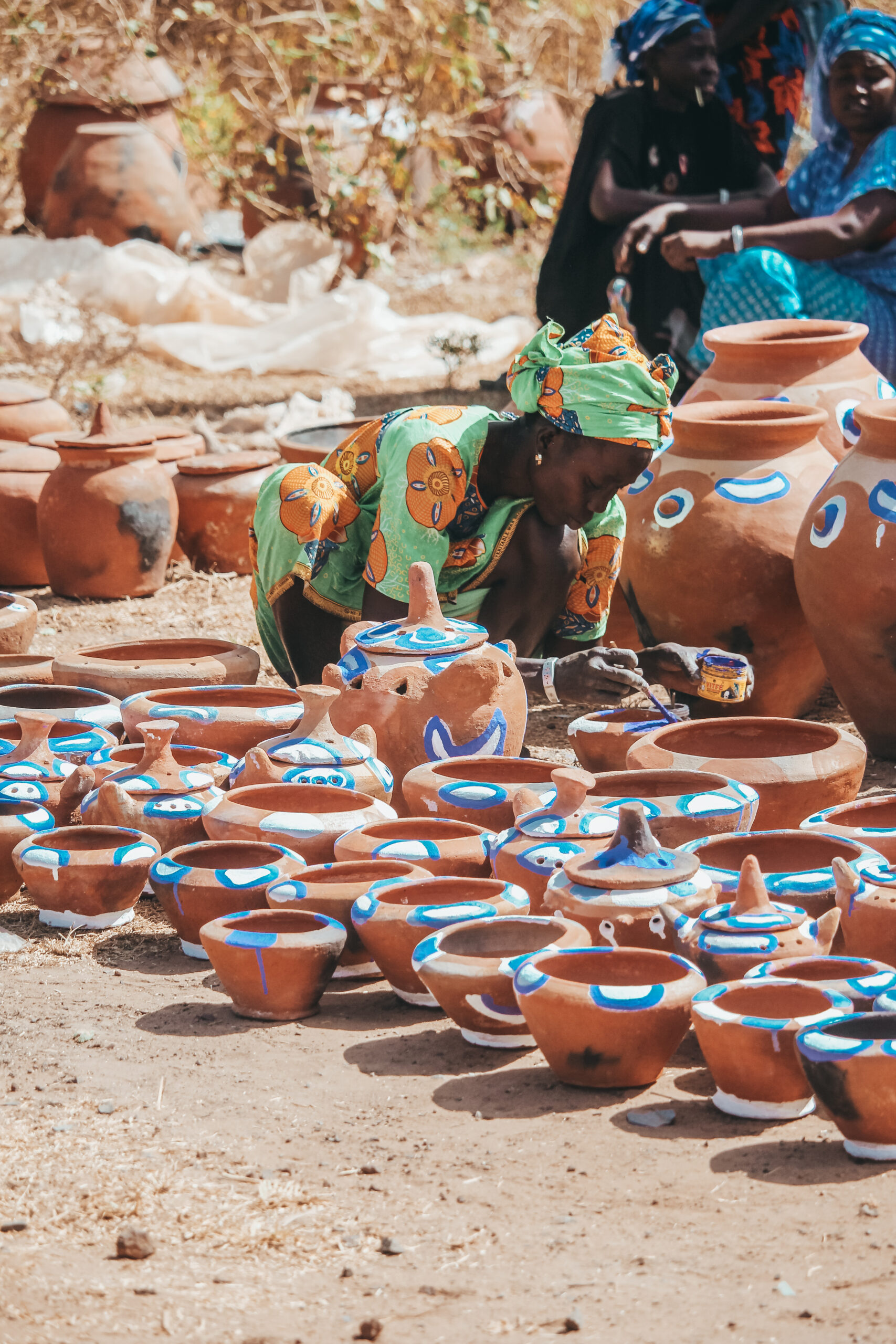 Mujer gambiana dibujando en el mercado 