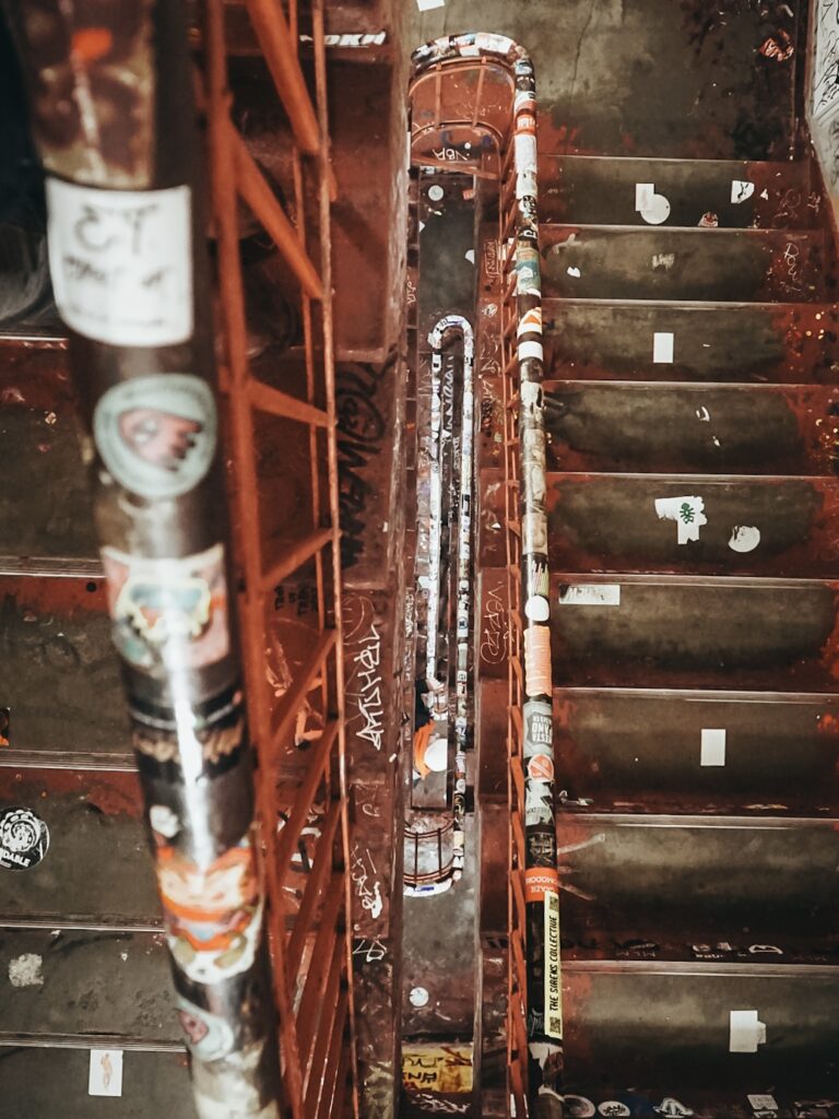 Escalera con pintadas y pegatinas en Dead Chicken Alley