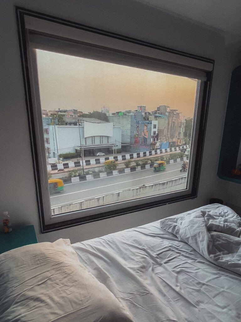Si buscas quedarte en una zona más o menos céntrica, este hotel es perfecto. Se sitúa en el mismísimo corazón de Nueva Delhi y a unos 5 minutos caminando de la estación de metro New Delhi Airport Express. El hotel en sí, está bastante viejo. Las habitaciones son espaciosas, pero muy antiguas, aunque tiene aire acondicionado. Lo mejor de la habitación, sin duda, es el gran ventanal que tiene, desde donde se puede observar la vida diaria de la cantidad de transeúntes que por allí pasan y observar sus costumbres.