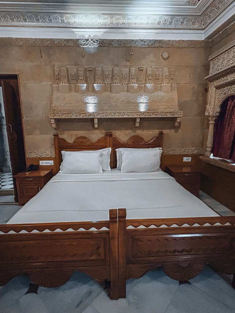 Las habitaciones son muy amplias, con una cama enorme y muy cómoda. Tiene aire acondicionado, wifi que funciona bastante bien y una nevera pequeña. El desayuno está incluido en el precio y es bastante completo. El personal del hotel te da dos botellas de agua al día gratuitas. En general, el personal es muy amable y servicial, nosotros contratamos con ello el traslado a Agra y, aunque al principio nos pusieron algún problema, al final nos lo solucionaron.