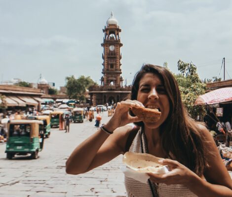 Noelia comiendo una samosa en el Sardar Market con la Torre del Reloj de fondo