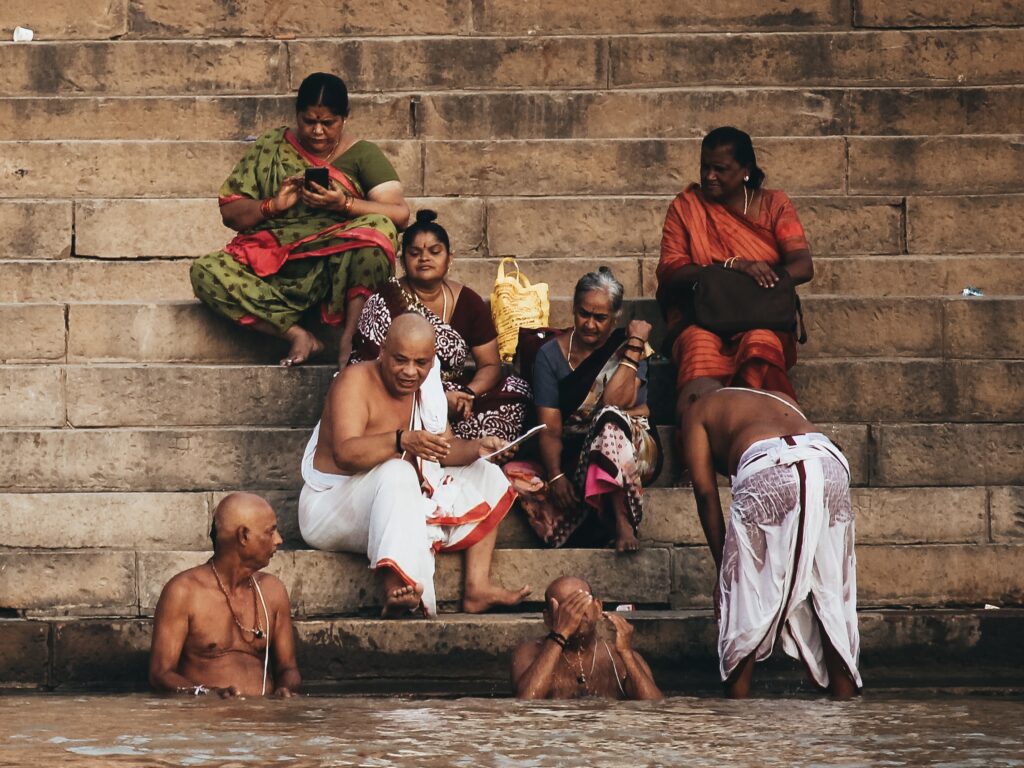 Hindúes en el ghat bañándose en el Ganges al amanecer