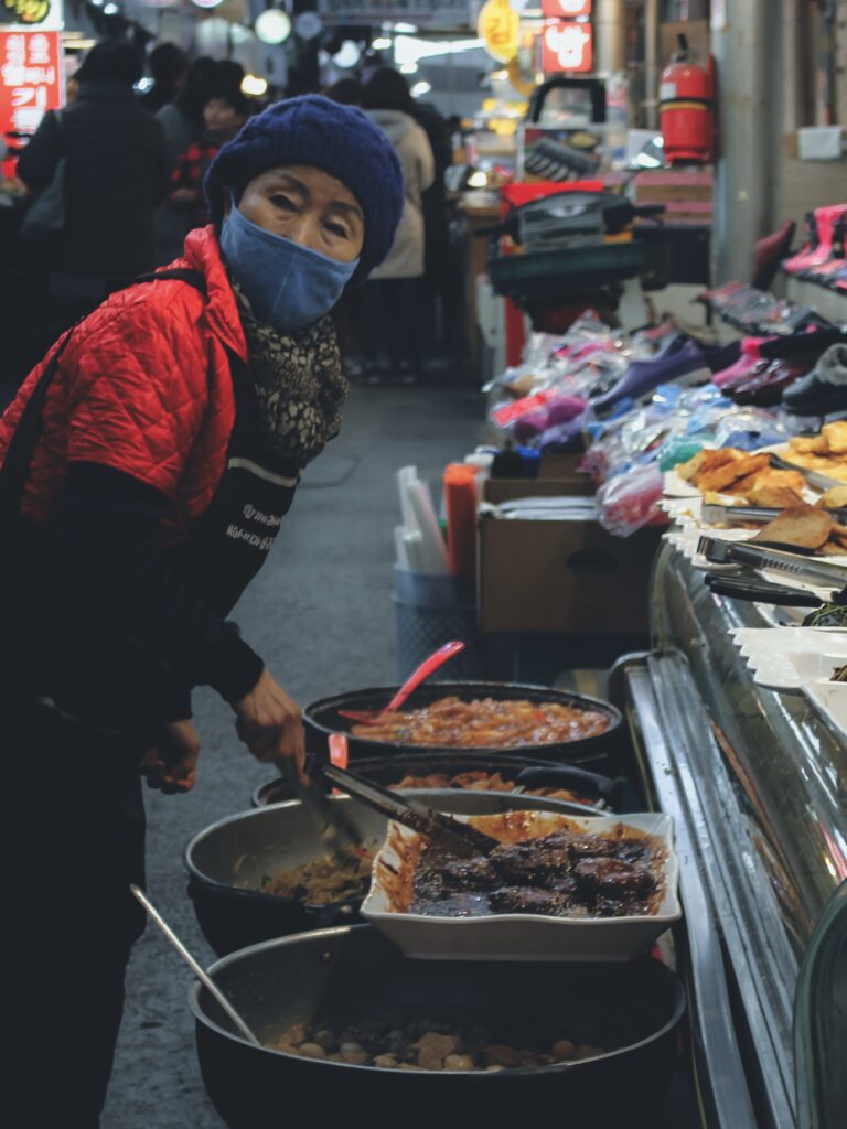 Señora cocinando en uno de los puestos del mercado de Tongin